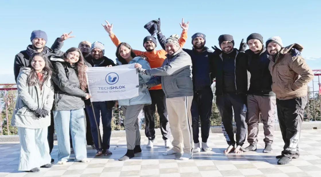 Techshlok team holding a company flag on an outing