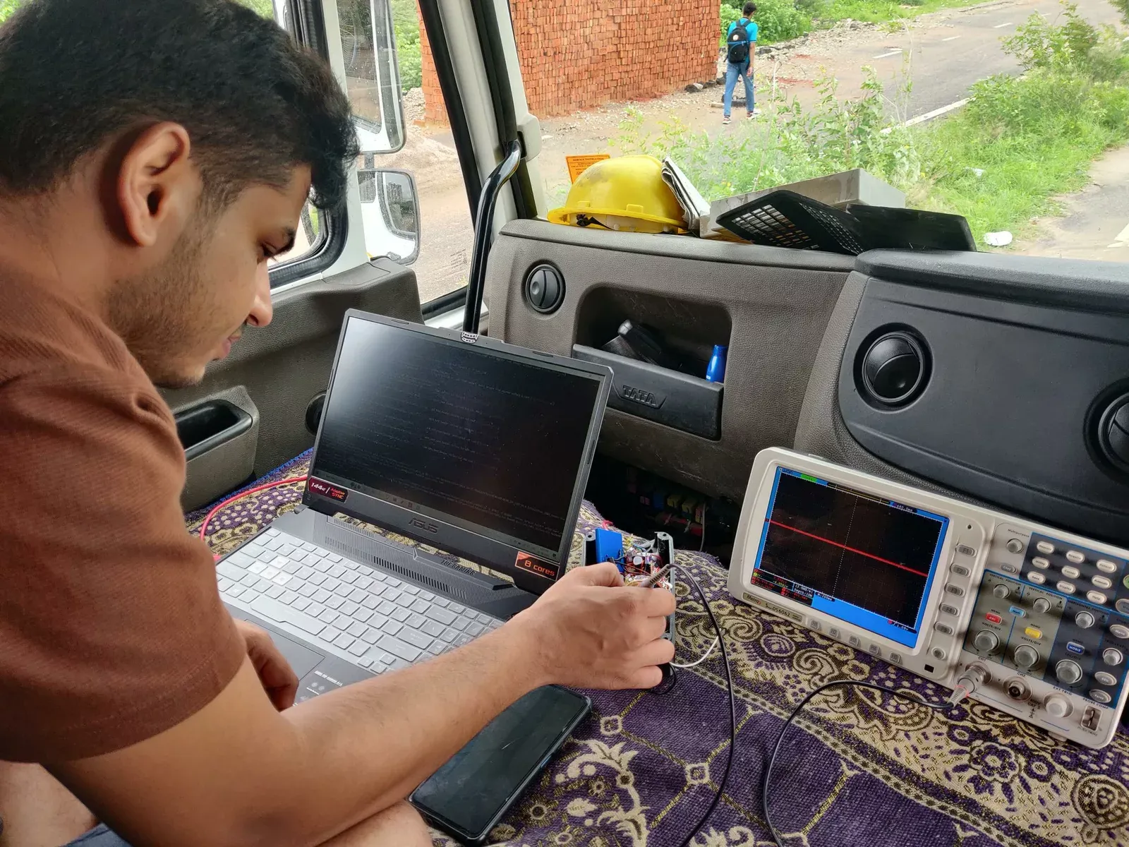 Field-testing the device on-site in a truck cab, using an oscilloscope for signal validation