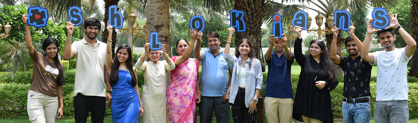 The Techshlok team holding up letters spelling #Shlokians outdoors