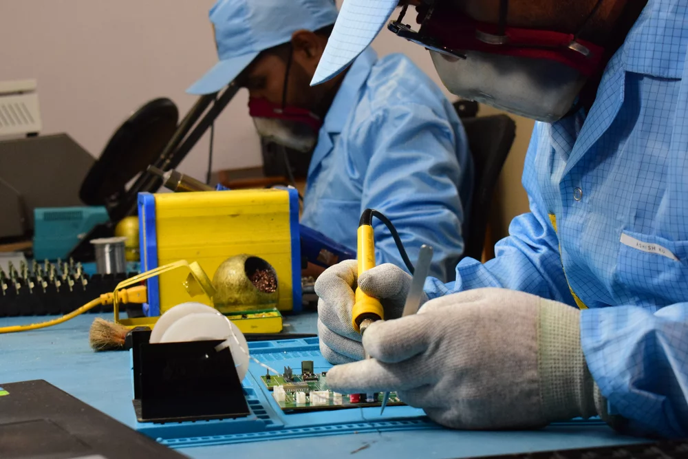 Technicians hand-soldering in an ESD-safe environment