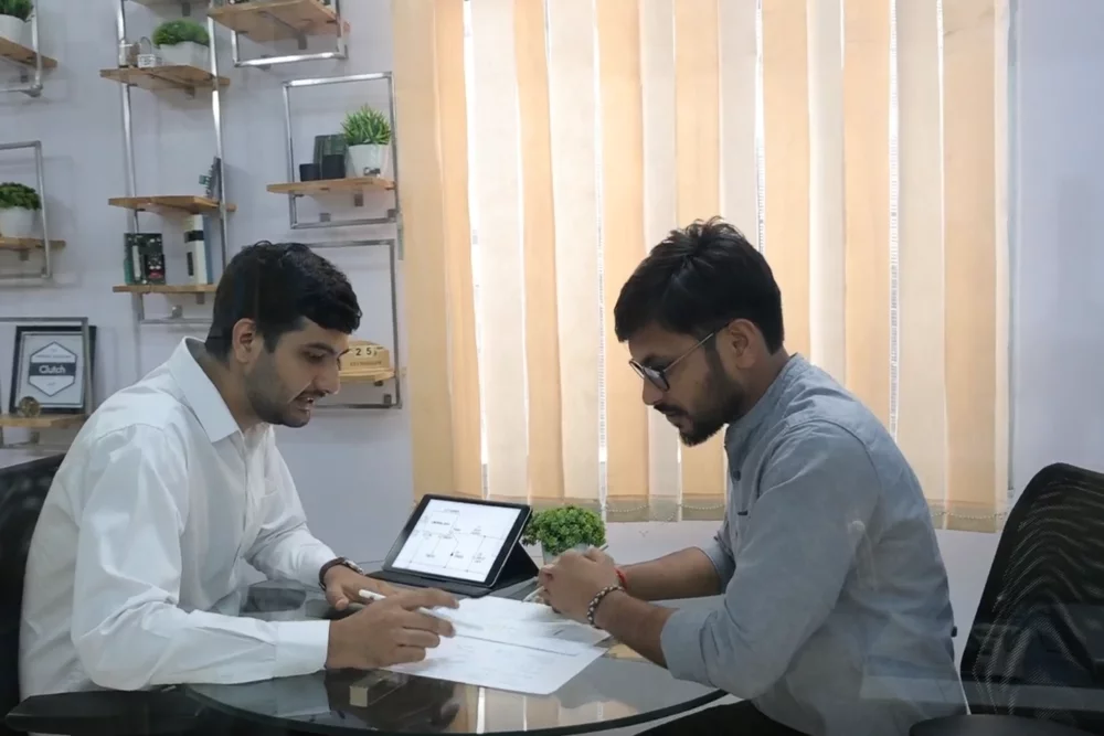 Two engineers reviewing a system architecture diagram together